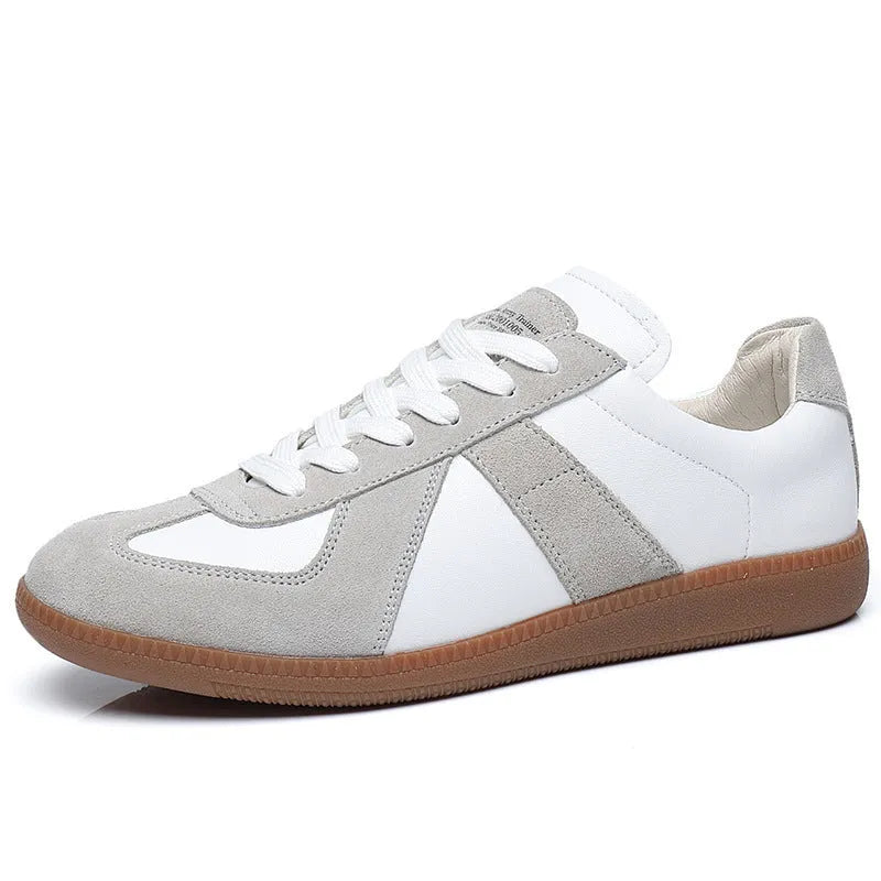 White retro unisex board sneakers with lace-up front and round toe on a rubber sole.