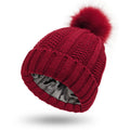Womens knitted beanie hat with faux fur pom pom, shown in a selection of colours including beige, black, and wine red.