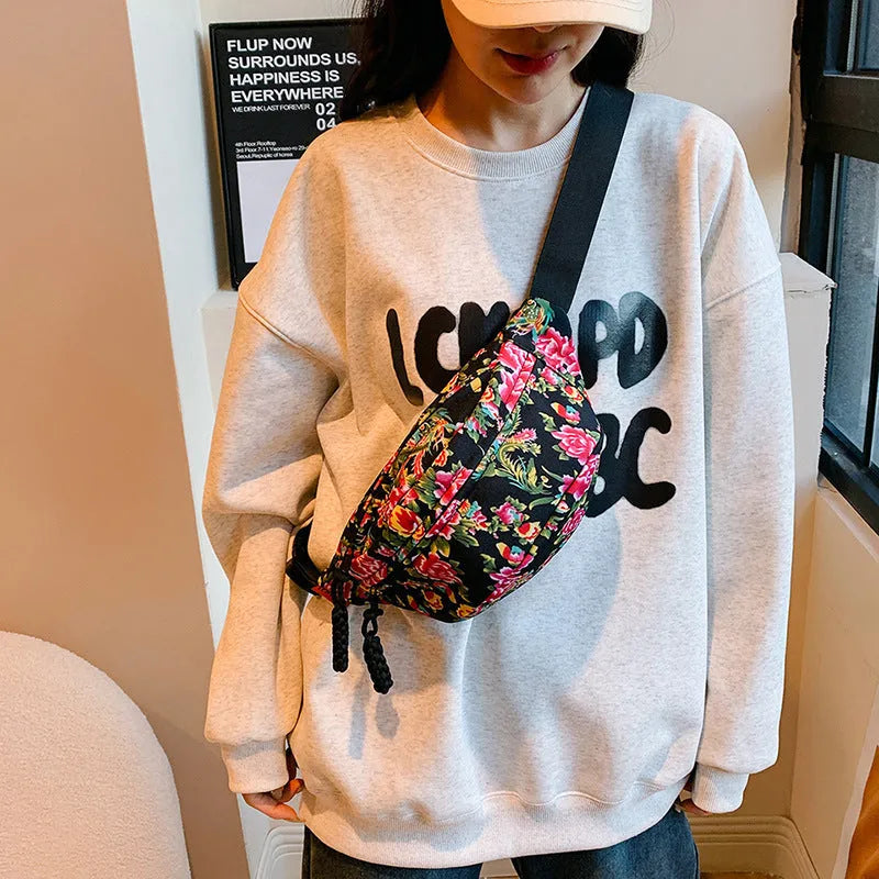 Women's black waist bag with large red flower design and western stitching details.