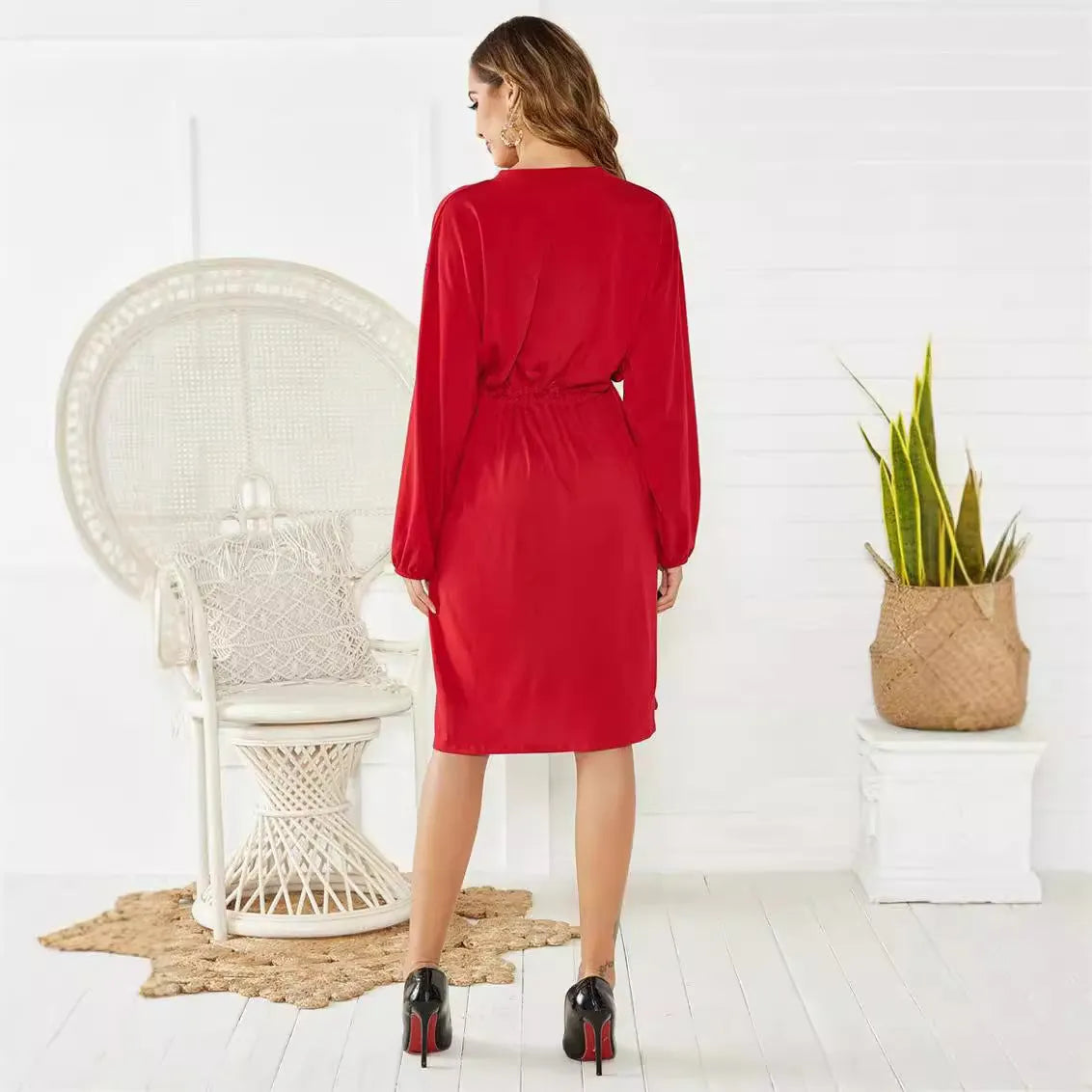 Black A-line midi dress with cinched belt and long sleeves on a mannequin