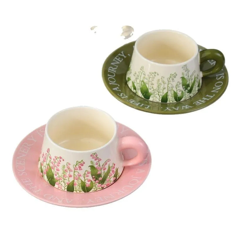 Ceramic coffee cup and saucer set with two spoons, shown in campanula and lanling grass designs.