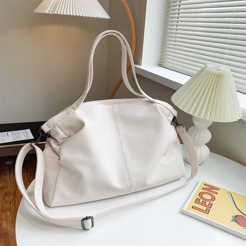 Large soft PU leather messenger bag with adjustable strap in black, shown open with internal pockets.
