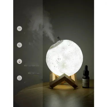 White spherical lunar humidifier night light with USB charging cable on a wooden surface.