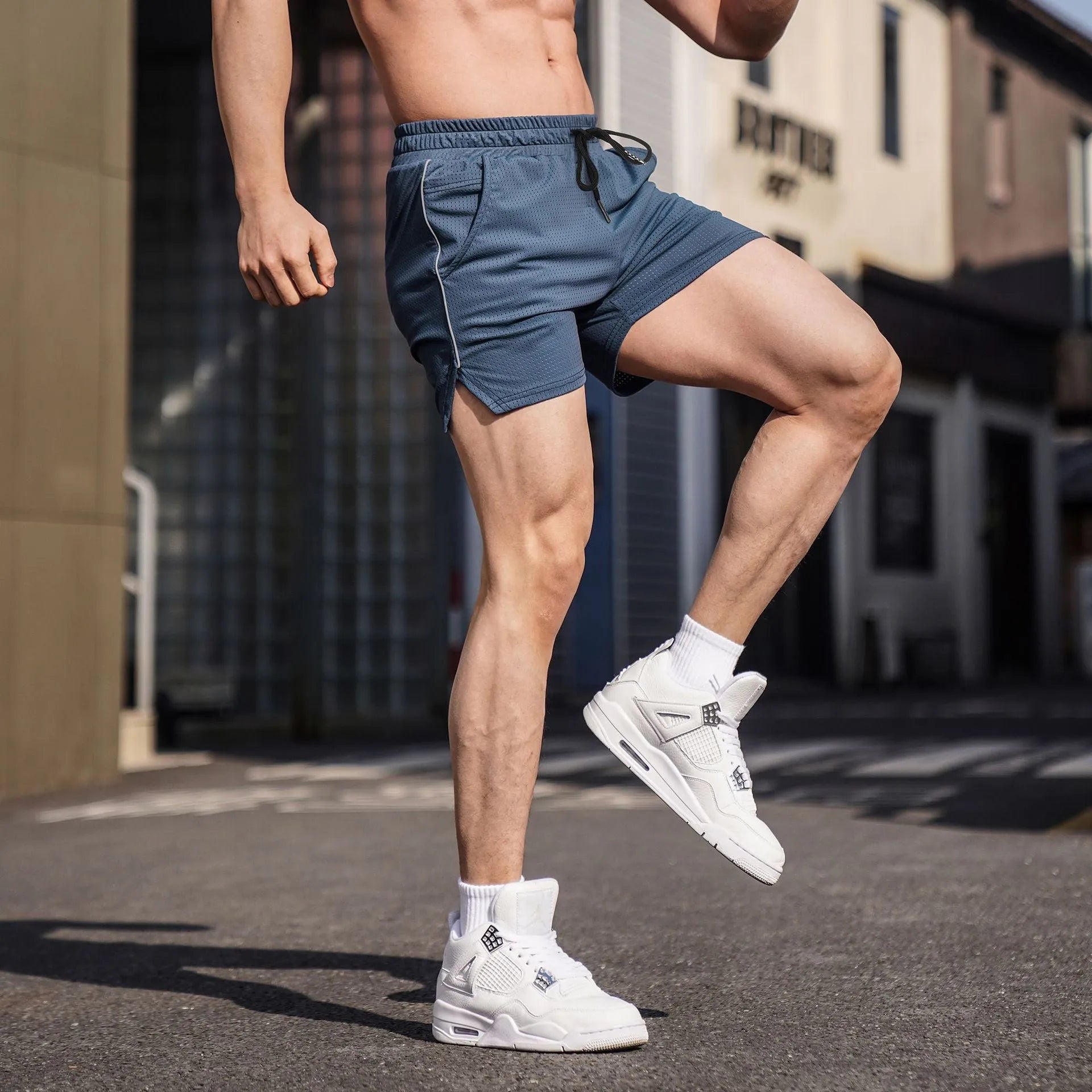 Man wearing straight-leg polyester fitness shorts in grey, showing casual sports style.