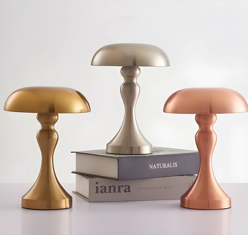 Metallic rechargeable touch desk lamp showing bronze, gold, and silver colour options on a wooden desk.