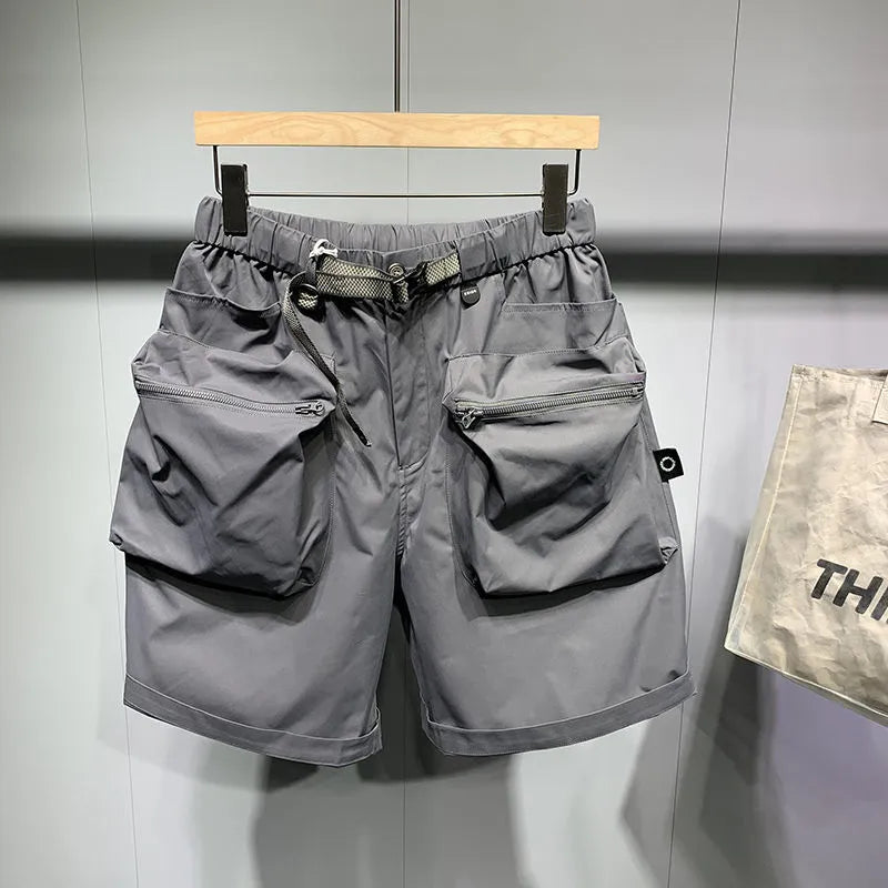 Man wearing large size black loose-fit work shorts with pockets, showing above-the-knee length.