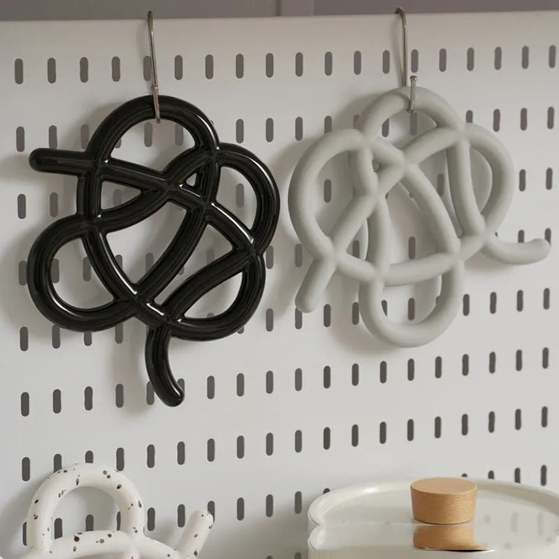 Ceramic heat proof mat with irregular shape on dining table, bright black solid colour