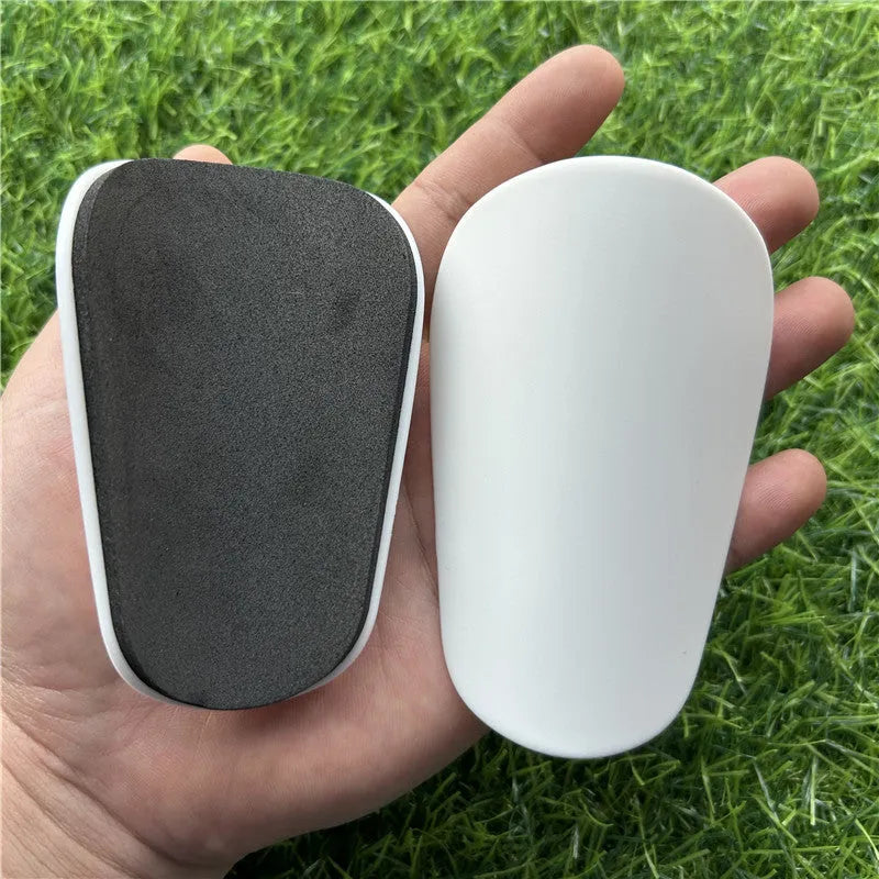Extra small mini football shin guards in black and white colours measuring 8x5cm