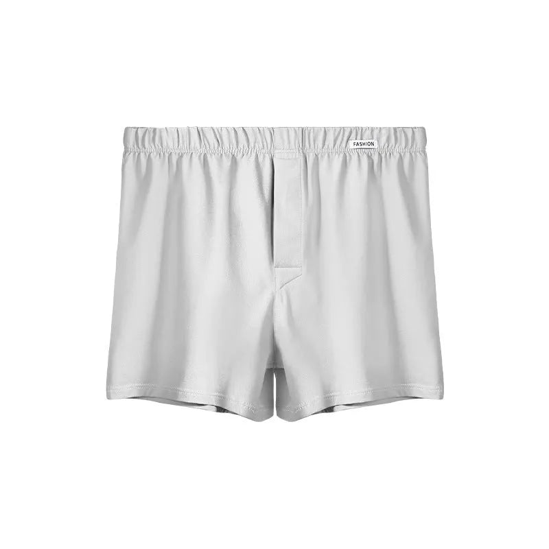 Men's loose-fitting cotton boxer shorts in a solid colour, shown in a light grey shade on a mid waist.