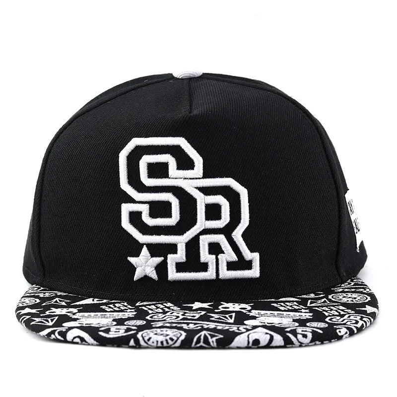 Cotton baseball cap with embroidered letters in black or white, showing adjustable strap.