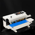 Handheld L1 steel seal style heat sealer with date printer on a countertop.