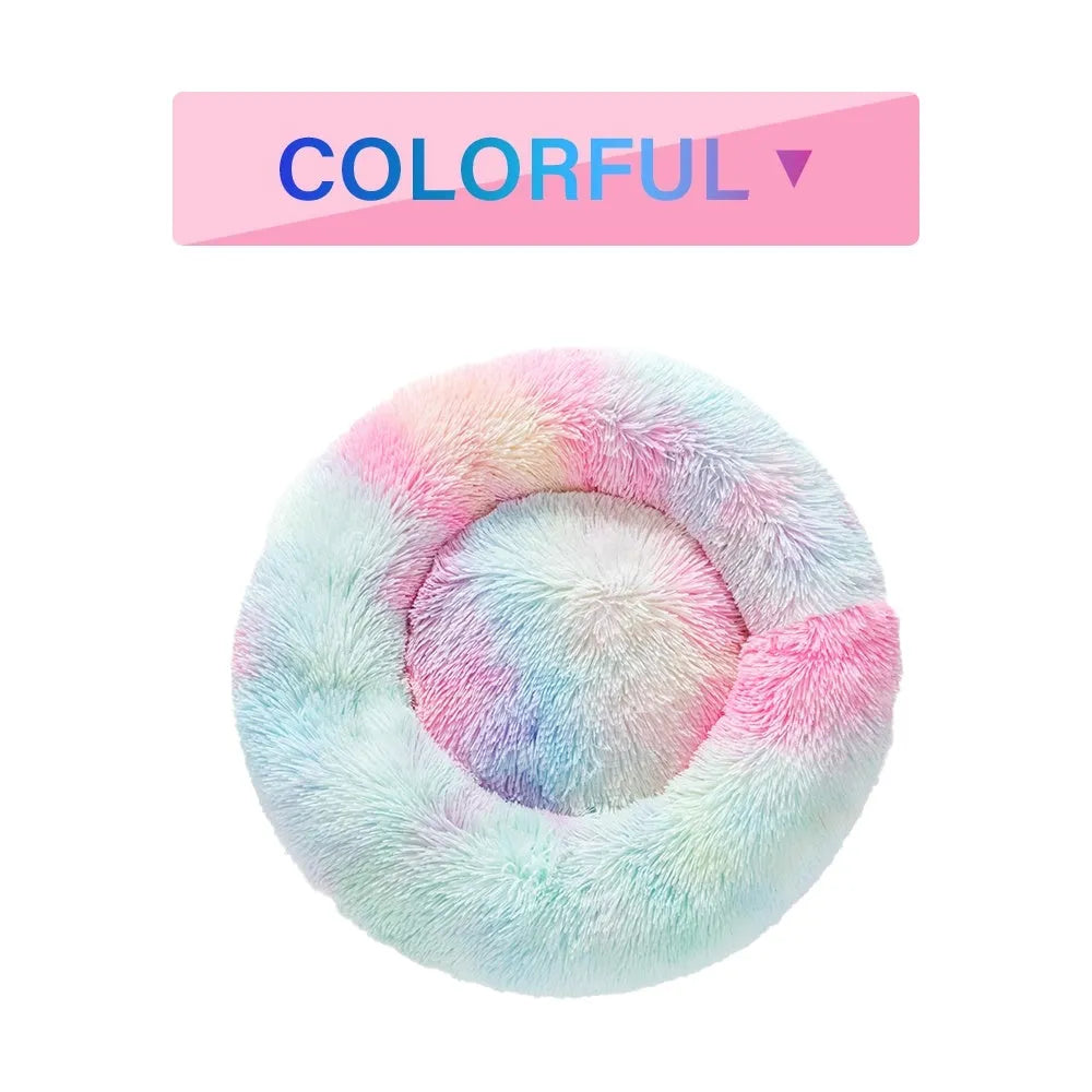 Fluffy donut-shaped dog bed in long plush fabric, shown in a light grey colour with a raised edge.