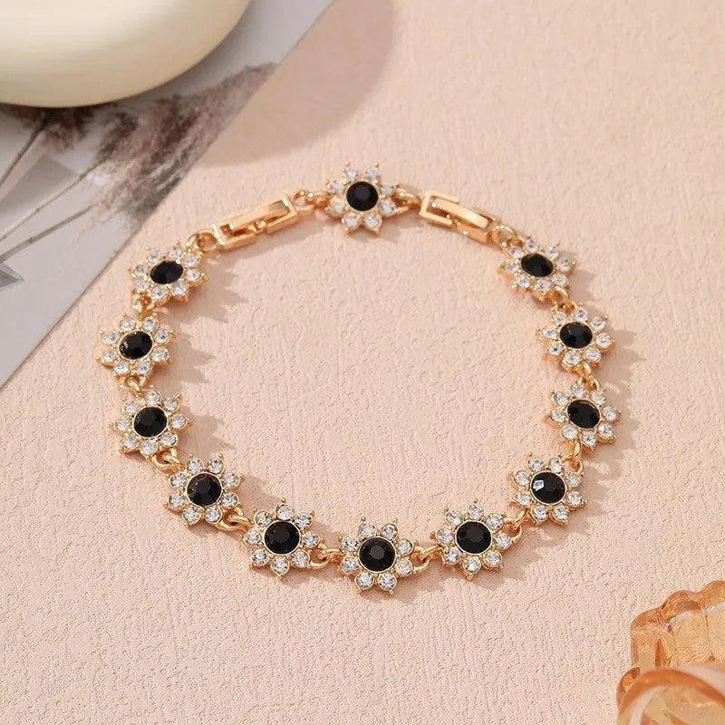 Electroplated zinc alloy bracelet with flower-shaped coloured gemstone charm in gold and silver colour variations