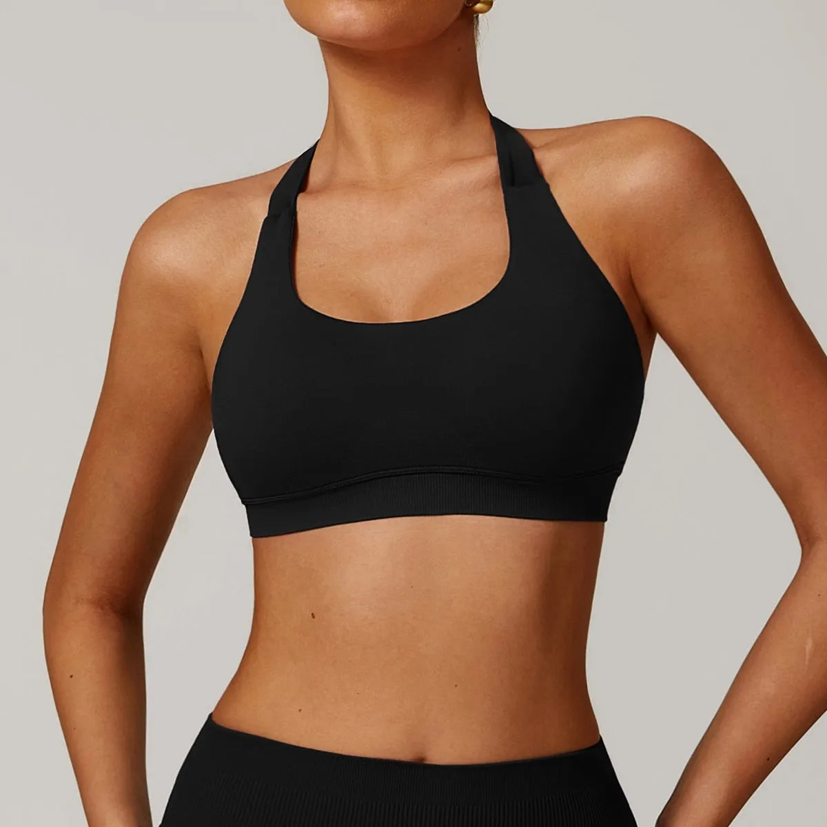 Women's black halter-neck yoga sports bra with removable padding on a mannequin.