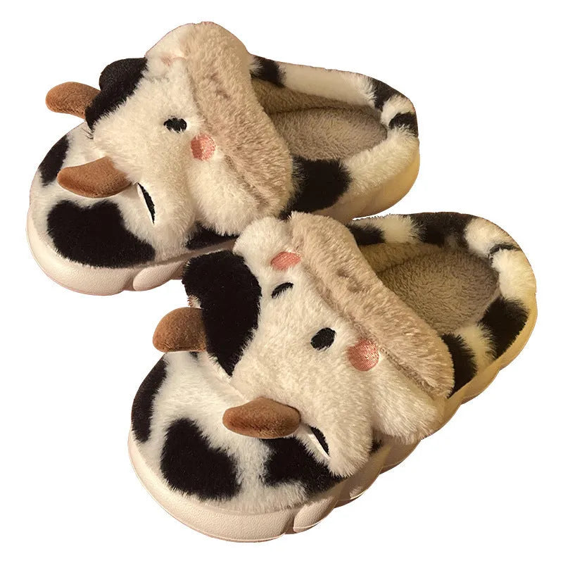 White cow-themed faux fur slippers with plush lining and textured non-slip soles.
