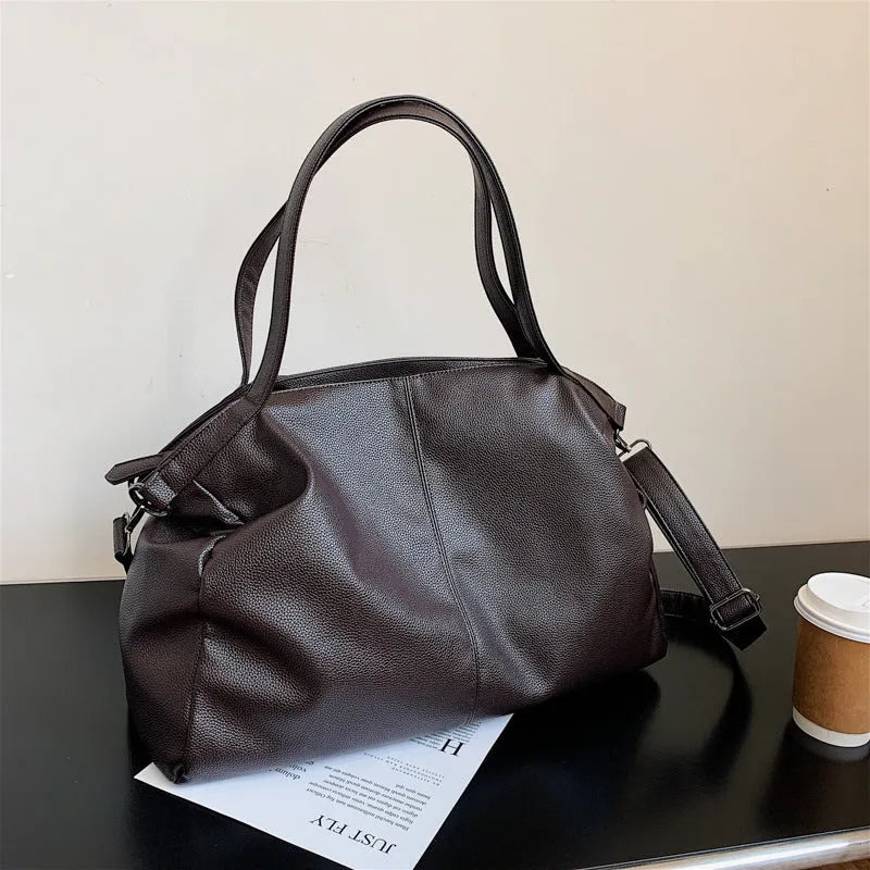 Large soft PU leather messenger bag with adjustable strap in black, shown open with internal pockets.