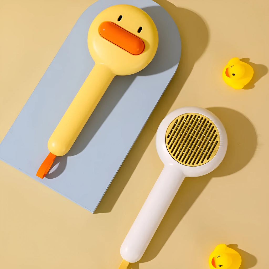Small yellow duck-shaped pet grooming comb with open section design and needle pins for hair removal