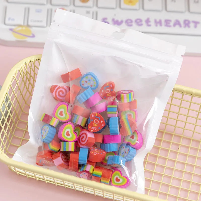50 colourful cartoon mini erasers in shapes of fruits, animals, and cakes, displayed next to a pearlescent film bag.
