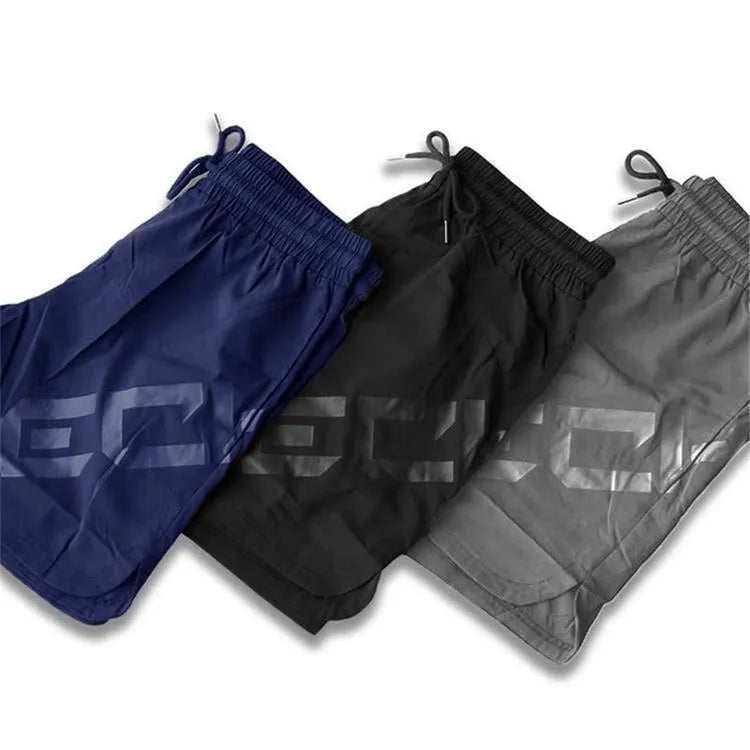 Men's black elastic training shorts with a knee-length cut on a plain background.