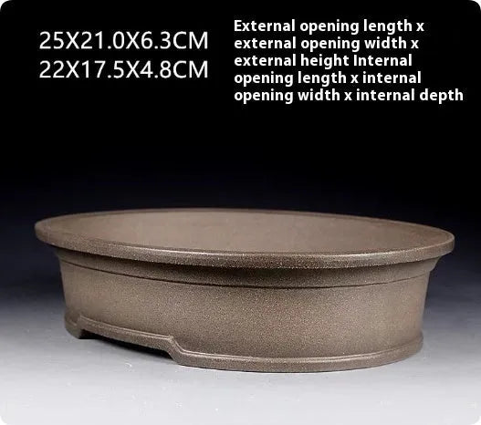 Handmade antique oval purple sand ceramic bonsai pot on a surface.