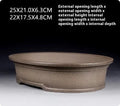 Handmade antique oval purple sand ceramic bonsai pot on a surface.