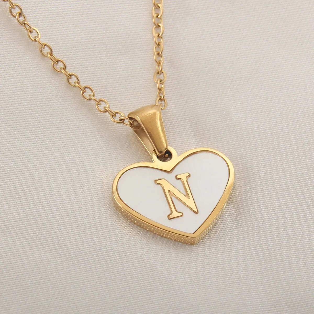 Gold plated heart-shaped white shell pendant personalised initial necklace on a stainless steel chain.