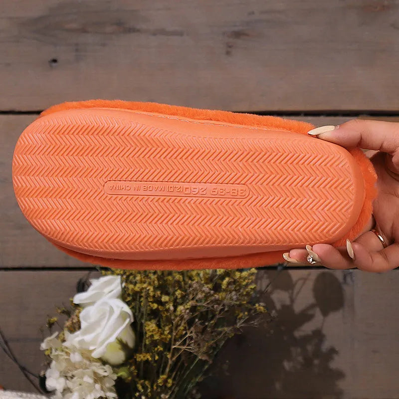 Orange women's pumpkin-themed plush slippers with a coral velvet upper and a flat non-slip sole.