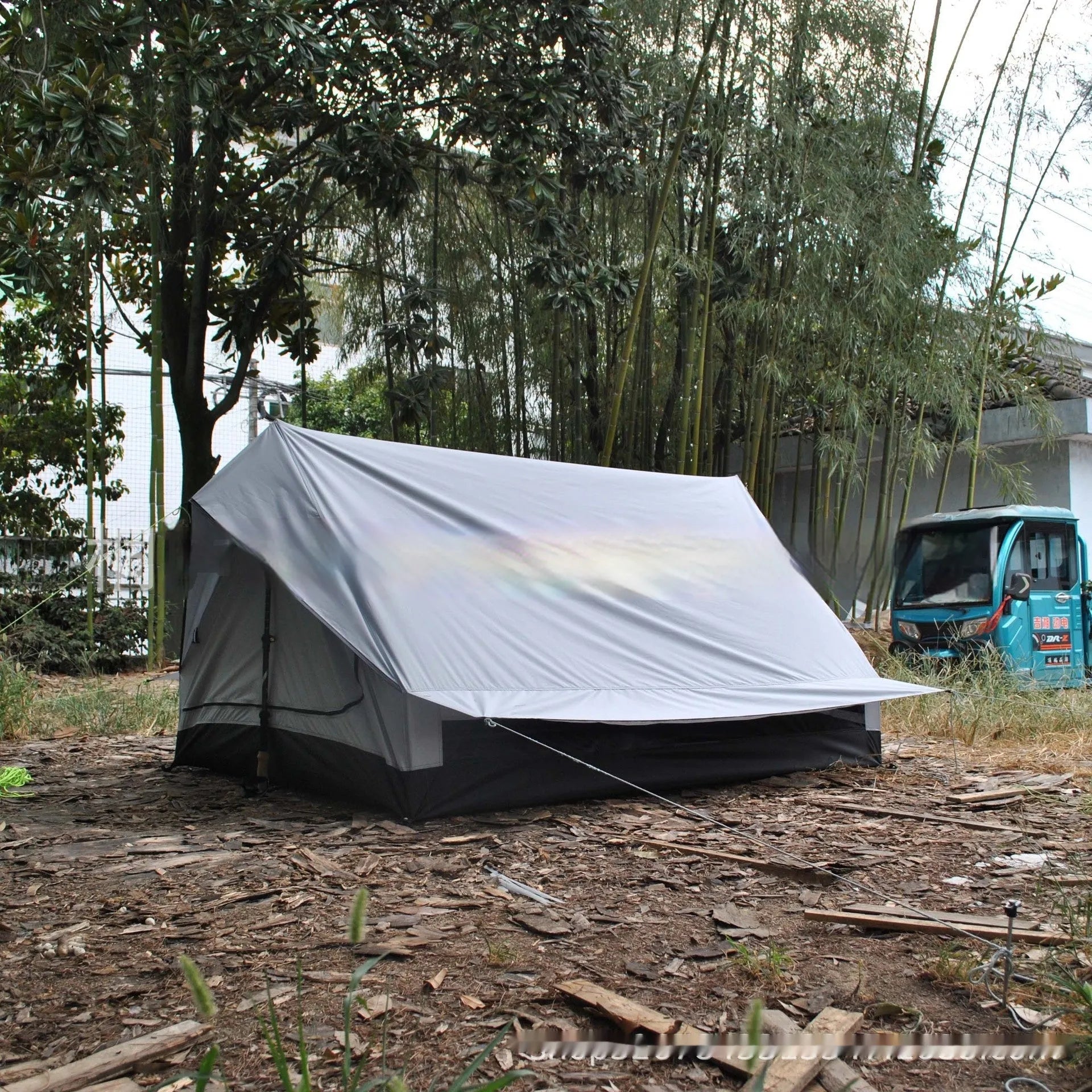 Brown A-line cabin tent pitched with hiking poles as structural support showing spacious interior for 2-3 people