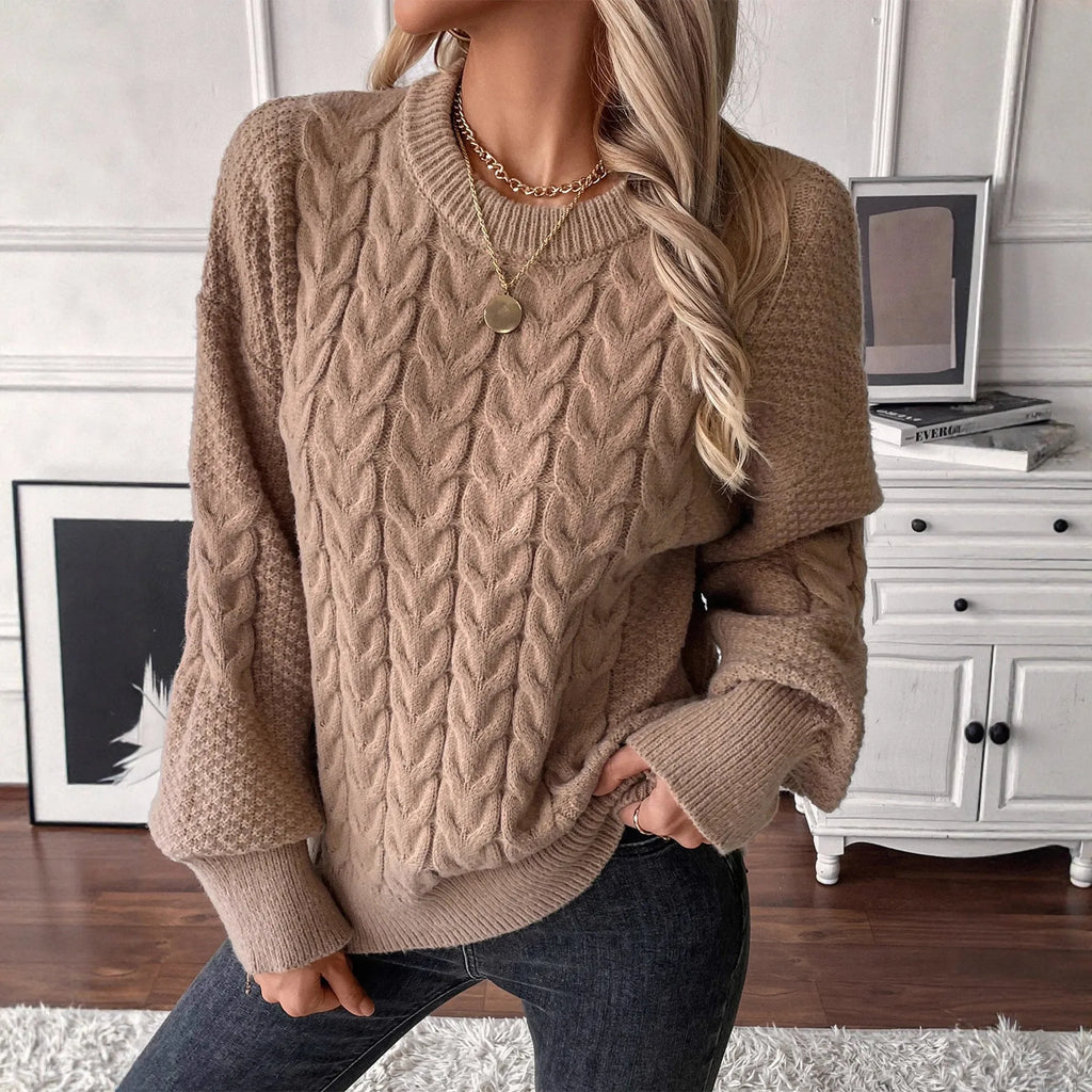 Women's loose beige round neck sweater showing twisted texture detail on the front.