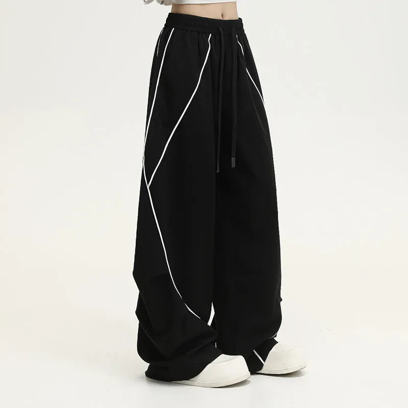Black and white striped wide-leg hip hop sports trousers with pleats, shown laid flat.