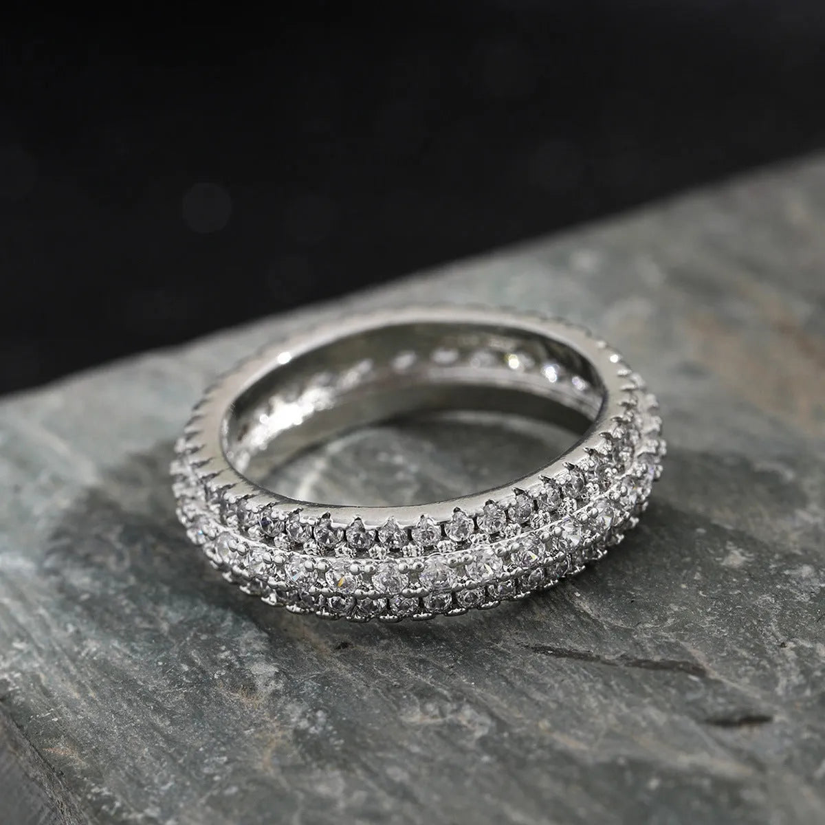 Geometric copper ring with triangular zircon inlay, shown in white gold plating.