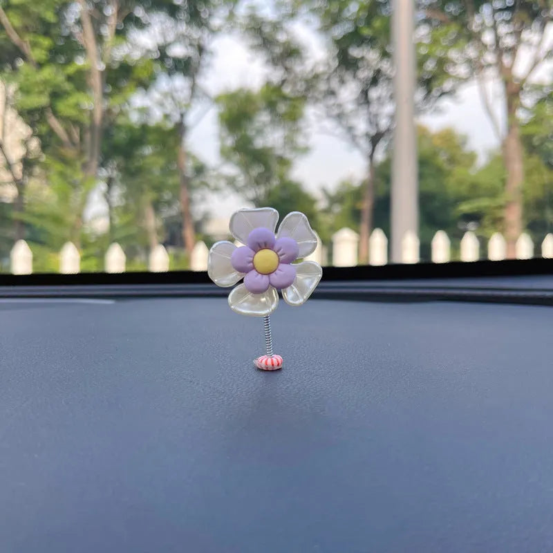 Small colourful plastic swing car decoration hanging ornament in blue, green, pink, purple, or yellow.