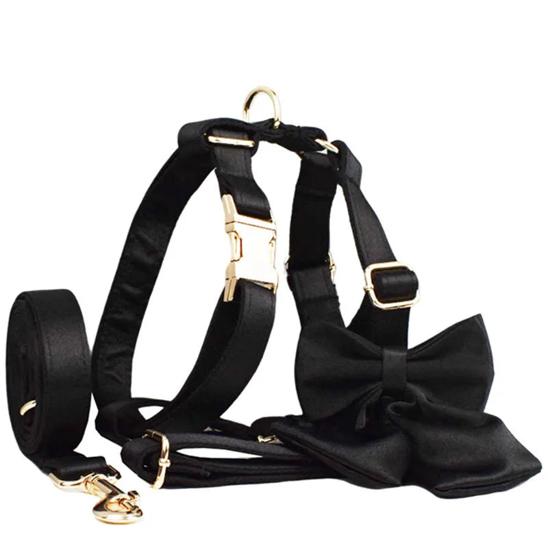 A soft cloth dog collar, leash, bow, and matching chest strap set laid out flat, showing coordinated colours.