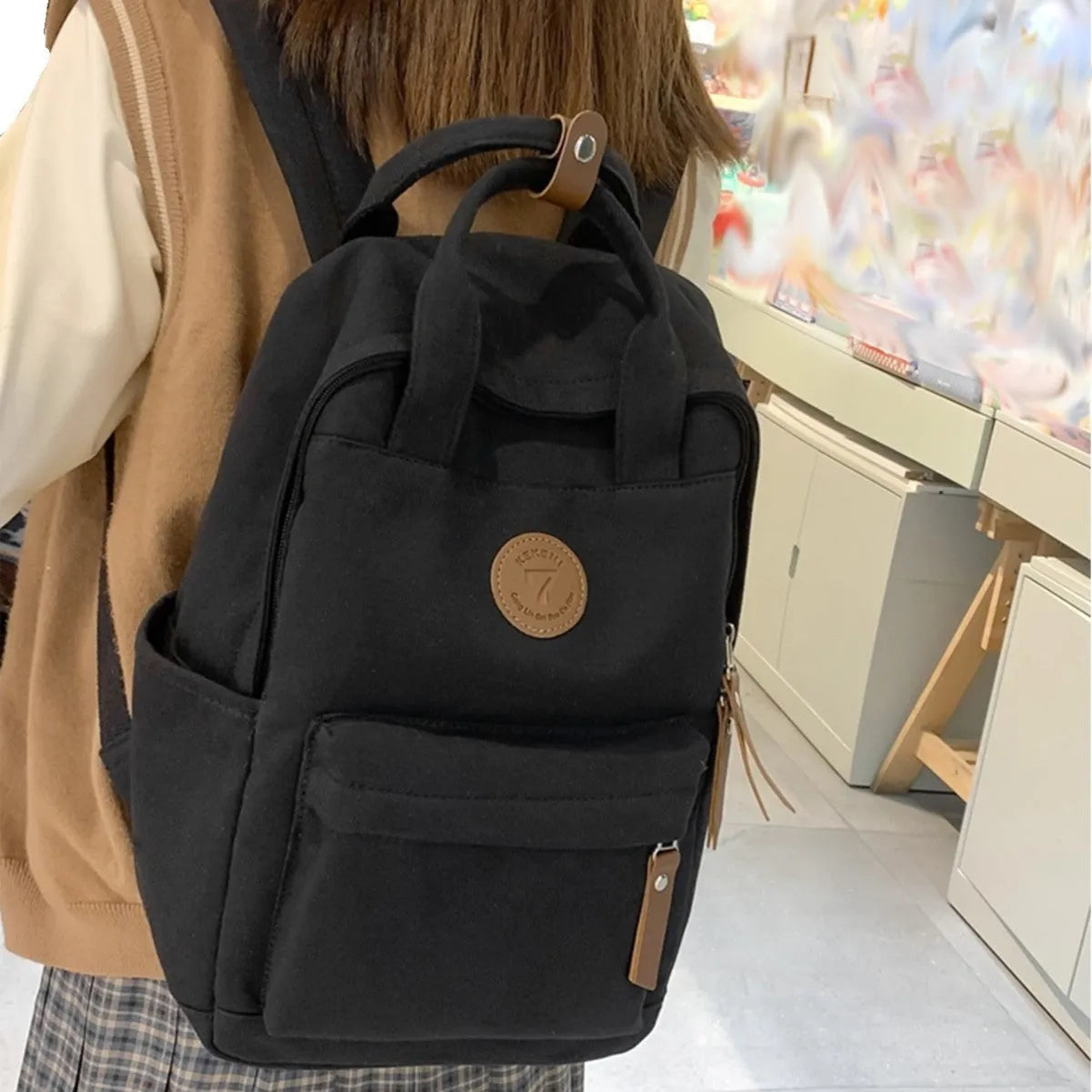 Black Oxford cloth unisex backpack with curved shoulder straps and retro sewing thread detailing