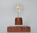 Magnetic levitation floating light bulb with UK plug on imitation wood base.