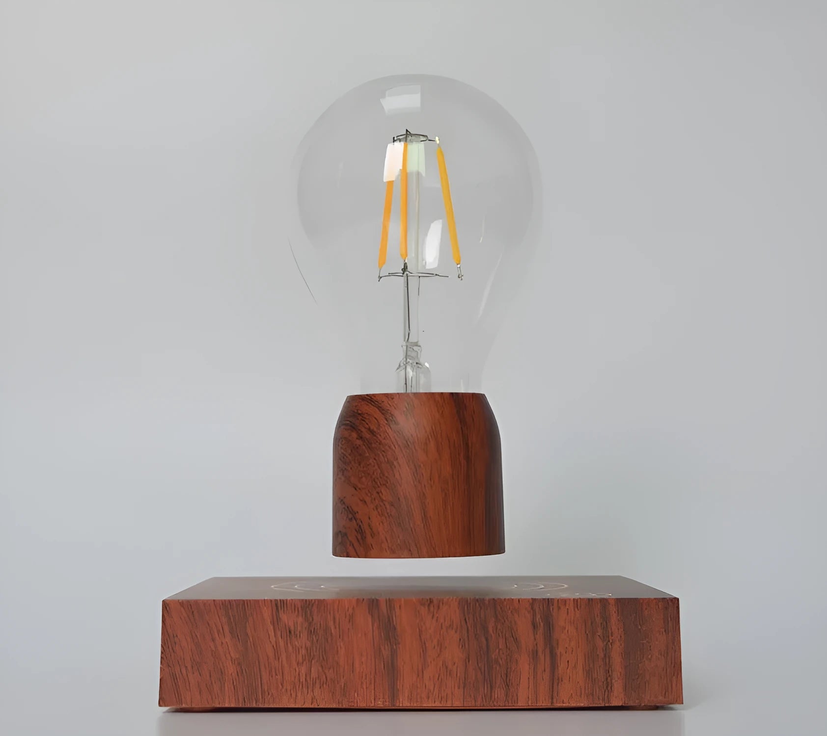 Magnetic levitation floating light bulb with UK plug on imitation wood base.