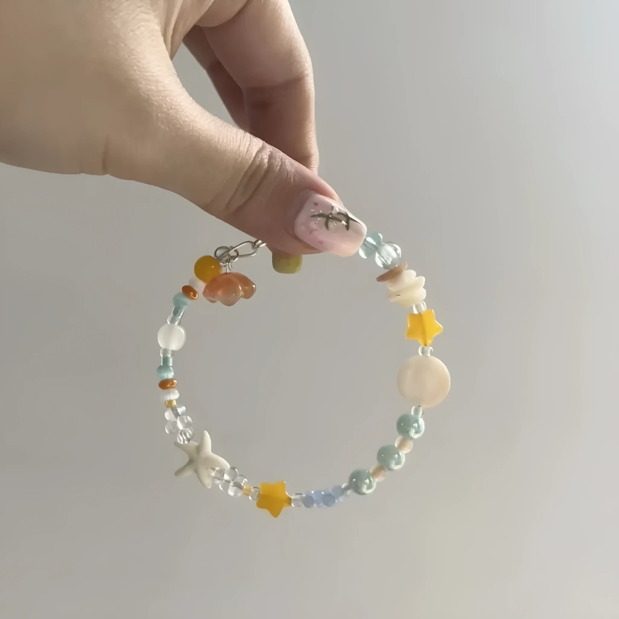 Orange mixed-alloy bracelet with diamond pattern and water-soaked bead seaside design