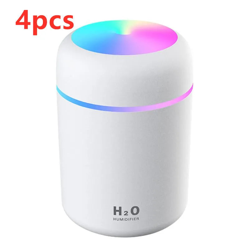 Pink USB desktop humidifier with coloured lights and water tank on a wooden desk