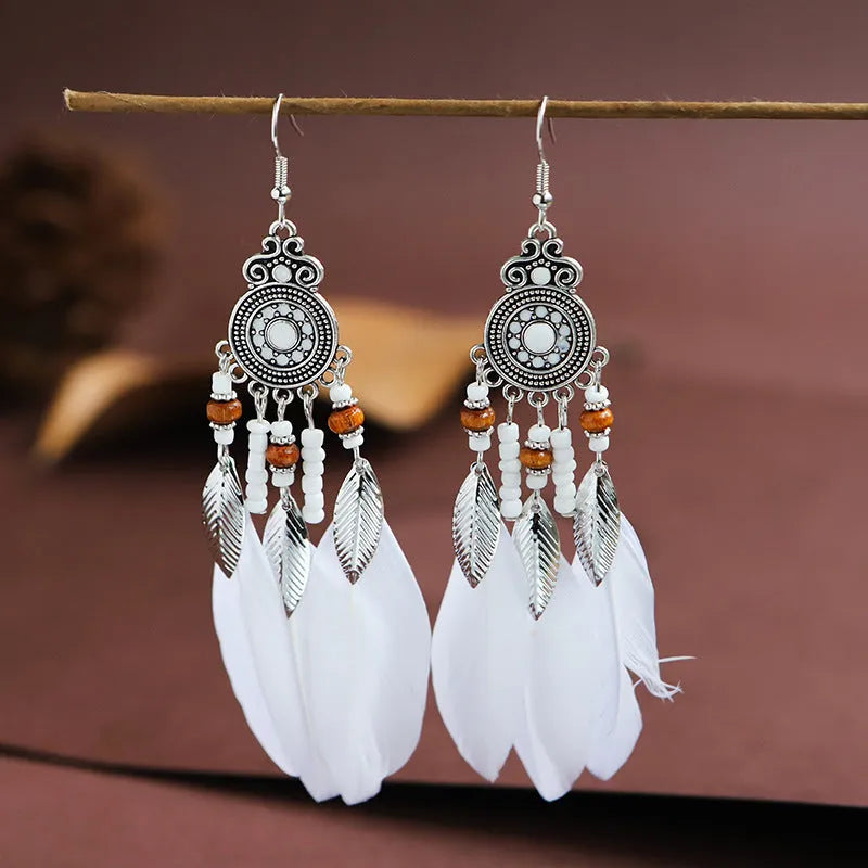 A pair of bohemian-style round drop earrings with a feather leaf pattern, shown in one of thirteen available colours.