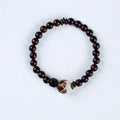 Rosewood bracelet with floral bead and knitted construction showing natural wood texture