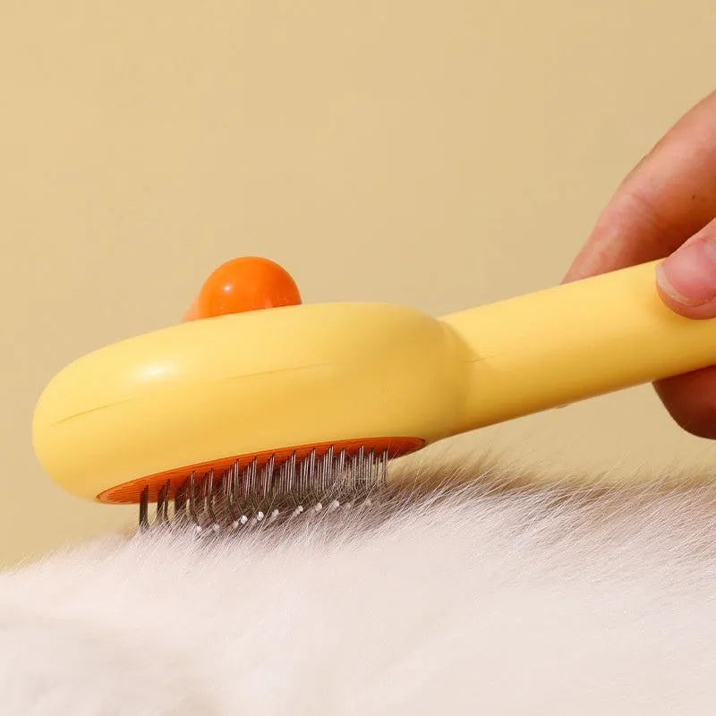 Small yellow duck-shaped pet grooming comb with open section design and needle pins for hair removal