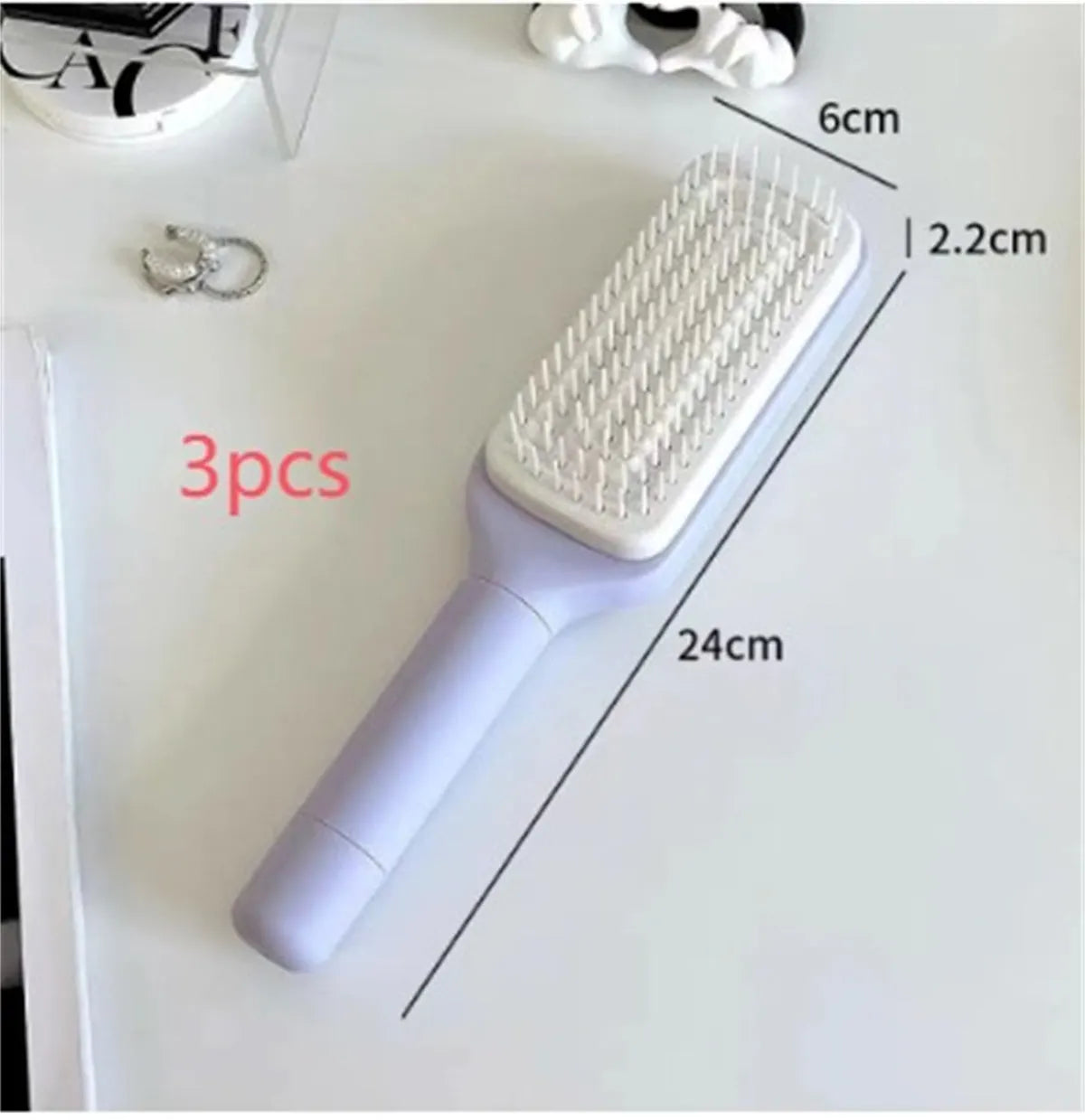Self-cleaning hair brush with rotating handle, anti-static teeth and scalp massage points in purple and grey colours
