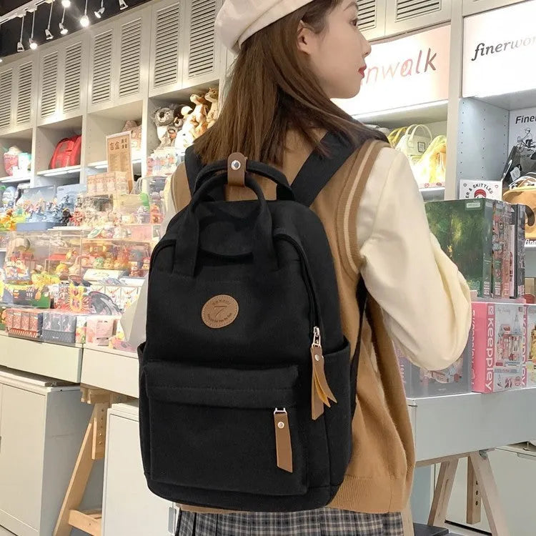 Black Oxford cloth unisex backpack with curved shoulder straps and retro sewing thread detailing