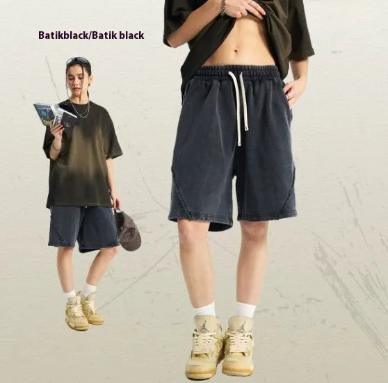 Men's loose black batik washed cotton shorts with patch craft design on a neutral background.