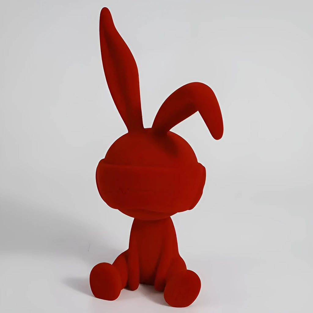 Suede blindfold rabbit resin table ornament in blue, green, or red colour on a shelf.