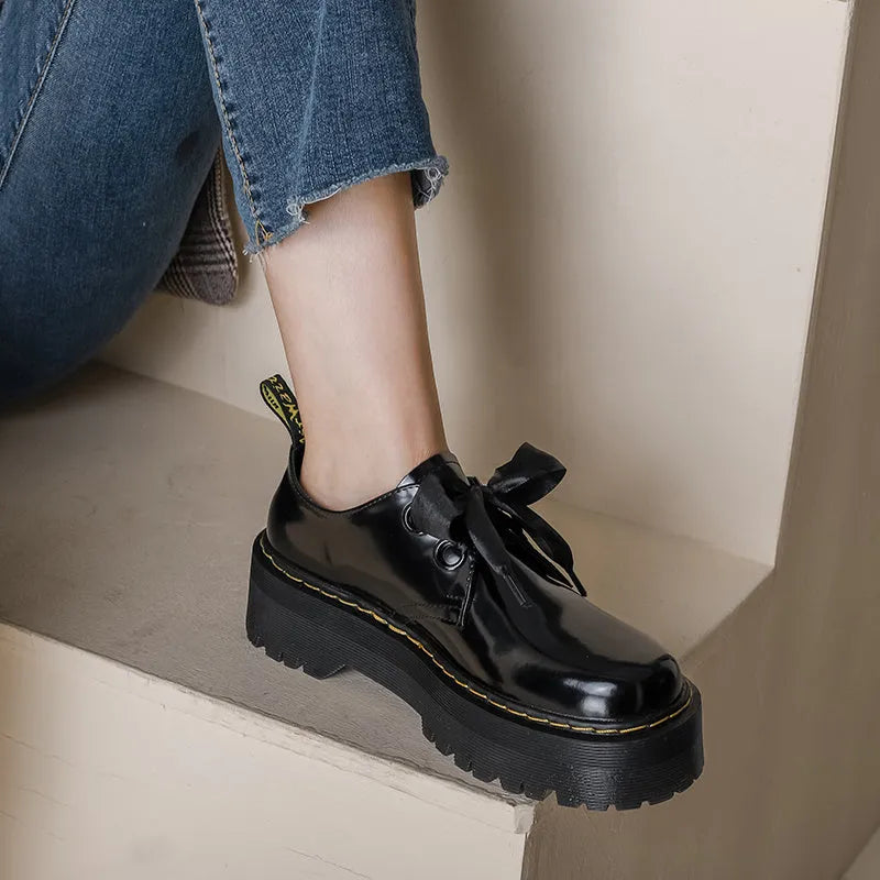Women's thick soled leather shoes with cross strap design and lace closure in black colour