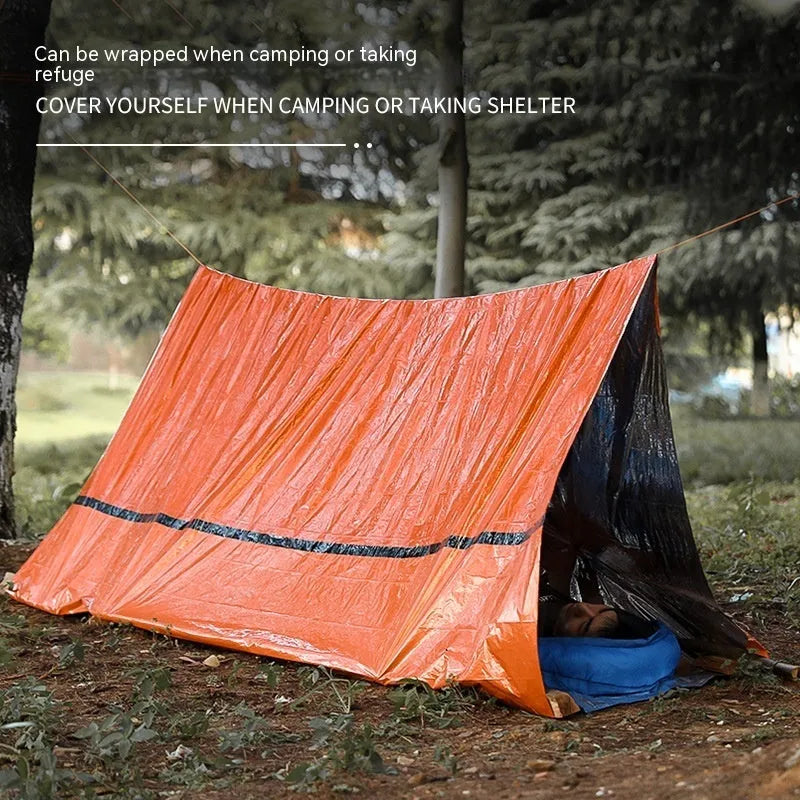 Orange portable disaster relief tent kit with sleeping bag, raincoat, and emergency blanket packed together.