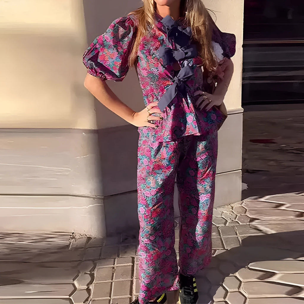 Women's floral print tie-neck trouser suit with puff sleeves, shown in the picture colour.