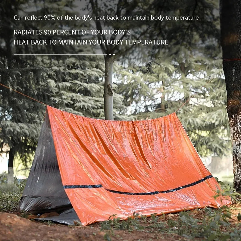 Orange portable disaster relief tent kit with sleeping bag, raincoat, and emergency blanket packed together.