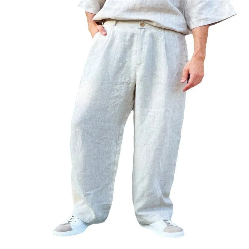 Man wearing loose grey linen blend high-waist pleated jogger pants